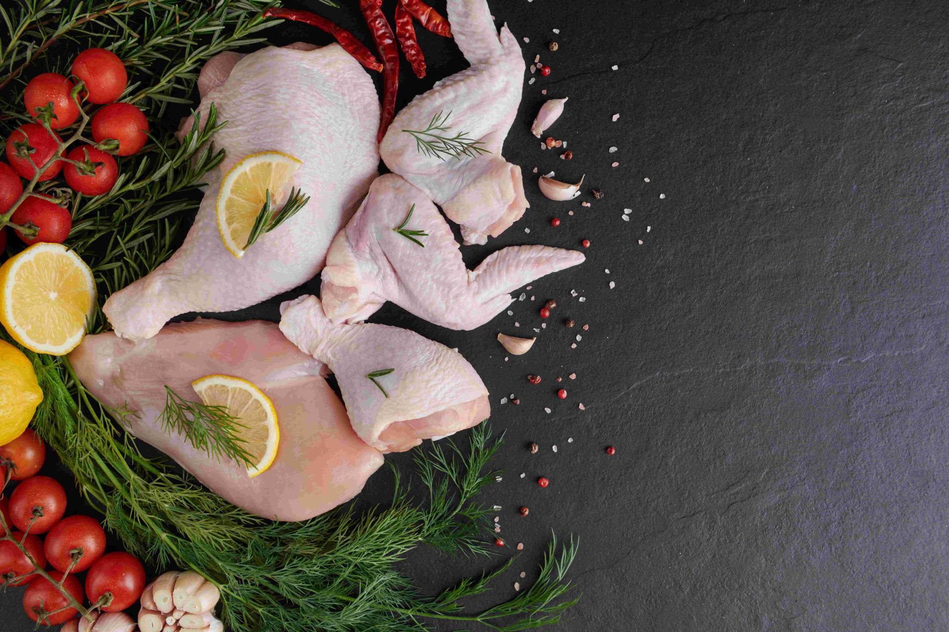 raw chicken parts preparation in a wooden chopping board with other vegetables